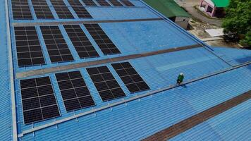 Worker Technicians are working to construct solar panels system on roof. Installing solar photovoltaic panel system. Men technicians carrying photovoltaic solar modules on roof. video