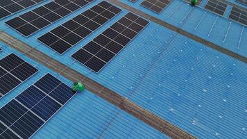Worker Technicians are working to construct solar panels system on roof. Installing solar photovoltaic panel system. Men technicians carrying photovoltaic solar modules on roof. video