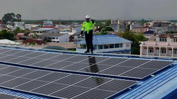 Worker Technicians are working to construct solar panels system on roof. Installing solar photovoltaic panel system. Men technicians carrying photovoltaic solar modules on roof. video