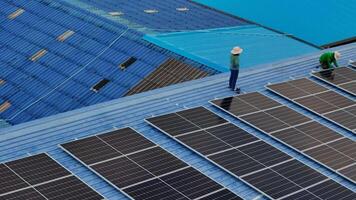 Worker Technicians are working to construct solar panels system on roof. Installing solar photovoltaic panel system. Men technicians carrying photovoltaic solar modules on roof. video
