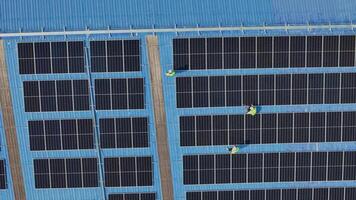 Worker Technicians are working to construct solar panels system on roof. Installing solar photovoltaic panel system. Men technicians carrying photovoltaic solar modules on roof. video
