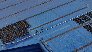 Worker Technicians are working to construct solar panels system on roof. Installing solar photovoltaic panel system. Men technicians carrying photovoltaic solar modules on roof. video
