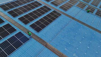 Worker Technicians are working to construct solar panels system on roof. Installing solar photovoltaic panel system. Men technicians carrying photovoltaic solar modules on roof. video