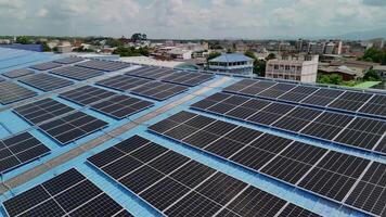 Top aerial view of solar roof system at the rooftop of factory warehouse. renewable energy of photovoltaic for reduce energy and carbon footprint. clean energy. solar panel and structure at building. video