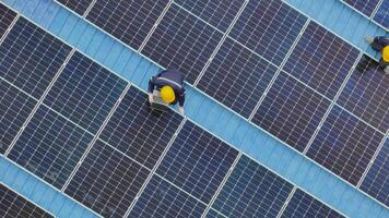 Worker Technicians are working to construct solar panels system on roof. Installing solar photovoltaic panel system. Men technicians carrying photovoltaic solar modules on roof. video