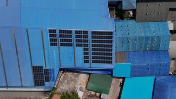Top aerial view of solar roof system at the rooftop of factory warehouse. renewable energy of photovoltaic for reduce energy and carbon footprint. clean energy. solar panel and structure at building. video