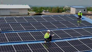 Worker Technicians are working to construct solar panels system on roof. Installing solar photovoltaic panel system. Men technicians carrying photovoltaic solar modules on roof. video
