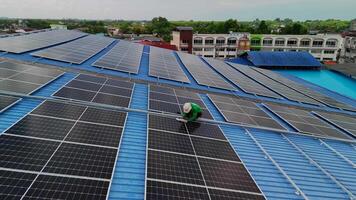Worker Technicians are working to construct solar panels system on roof. Installing solar photovoltaic panel system. Men technicians carrying photovoltaic solar modules on roof. video