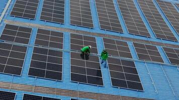 Worker Technicians are working to construct solar panels system on roof. Installing solar photovoltaic panel system. Men technicians carrying photovoltaic solar modules on roof. video