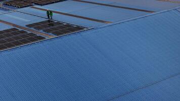 Worker Technicians are working to construct solar panels system on roof. Installing solar photovoltaic panel system. Men technicians carrying photovoltaic solar modules on roof. video