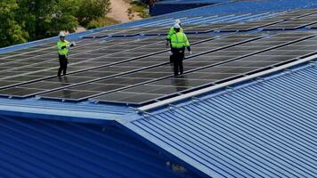 Worker Technicians are working to construct solar panels system on roof. Installing solar photovoltaic panel system. Men technicians carrying photovoltaic solar modules on roof. video