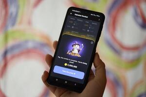 KYIV, UKRAINE - JUNE 26, 2024 Hamster Kombat telegram mini-game in tap 2 earn genre. Tap game on smartphone in hand photo