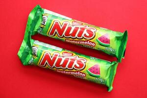 KYIV, UKRAINE - APRIL 20, 2024 Nuts watermelon taste chocolate bar manufactured by Nestle company. Small chocolate with nuts and nougat in colorful wrapping photo