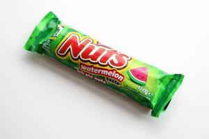 KYIV, UKRAINE - APRIL 20, 2024 Nuts watermelon taste chocolate bar manufactured by Nestle company. Small chocolate with nuts and nougat in colorful wrapping photo