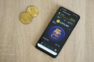 KYIV, UKRAINE - APRIL 20, 2024 Hamster Kombat telegram bot on smartphone screen. Hamster Kombat is a viral Telegram crypto game for earn HMSTR tokens by managing virtual crypto exchange photo