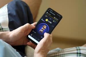 KYIV, UKRAINE - APRIL 20, 2024 Hamster Kombat telegram bot on smartphone screen. Hamster Kombat is a viral Telegram crypto game for earn HMSTR tokens by managing virtual crypto exchange photo