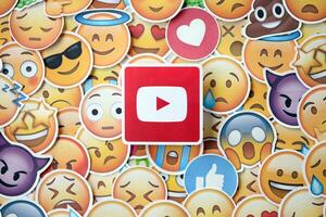 KYIV, UKRAINE - APRIL 20, 2024 YouTube logo and large set of stickers with Emoji yellow faces. Emoji is a pictogram or smiley embedded in text and used in electronic messages photo