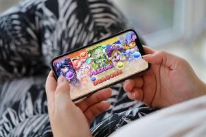 Puzzle and dragons mobile iOS game on iPhone 15 smartphone screen in female hands during mobile gameplay photo