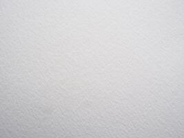Grungy white watercolor paper backdrop with rough textured surface for design projects photo