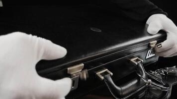 Person opens a briefcase full of gold bars. Handcuffed case with fine gold bars. Shiny gold bars in close-up view, 4K resolution video