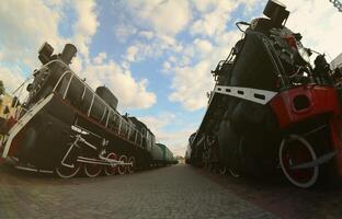 Photo of old black steam locomotives of the Soviet Union. Strong distortion from the fisheye lens