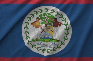 Belize flag depicted on folded wavy fabric of old cloth photo