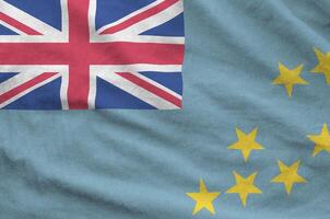 Tuvalu flag depicted on folded wavy fabric of old cloth photo