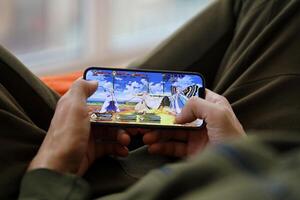 Fate Grand Order mobile iOS game on iPhone 15 smartphone screen in male hands during mobile gameplay photo