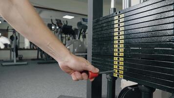 Increasing amount of weight plates during exercise. Black iron plates stacked on a weight-lifting machine at the gym video