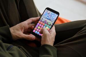 Puzzle and dragons mobile iOS game on iPhone 15 smartphone screen in male hands during mobile gameplay photo