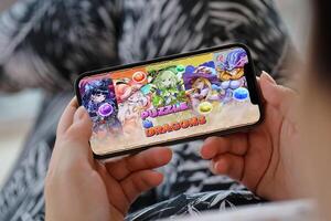 Puzzle and dragons mobile iOS game on iPhone 15 smartphone screen in female hands during mobile gameplay photo