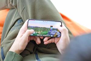 Minecraft mobile iOS game on iPhone 15 smartphone screen in male hands during mobile gameplay photo