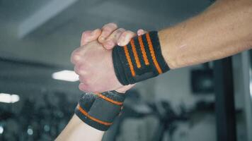Powerful manly handshake of athletes. Two athletes shaking hands at the gym. Strong bodybuilders hands, selective focus, close up view. video