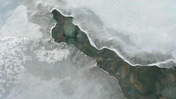 Melting ice forming a river. Springtime, brittle ice, and water flow. video
