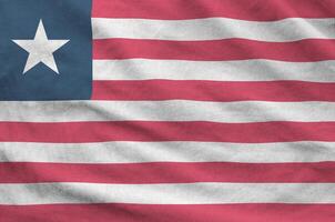 Liberia flag depicted on folded wavy fabric of old cloth photo