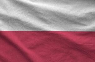 Poland flag depicted on folded wavy fabric of old cloth photo