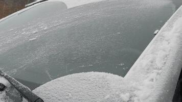 bil i de snö. bil vindrutetorkare rengöring snö på de glasyr vindskydd. fordon vänster på de gata i vinter- video