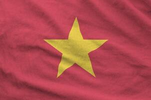 Vietnam flag depicted on folded wavy fabric of old cloth photo