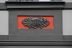 a decorative flower on the side of a building photo