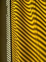 Yellow curtains with beautiful shade from blinds on a sunny day. Abstract background. photo