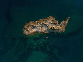Aerial drone view of a deserted island in the sea, showcasing the beauty and serenity of a remote paradise photo