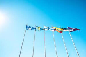 The flags of the Baltic countries and Scandinavia waving in the sky of a beautiful summer day photo