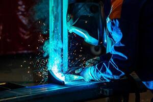 Skillful metal worker working with arc welding machine in factory while wearing safety equipment Metalwork manufacturing and construction maintenance service by manual skill labor concept photo