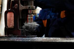 Close up of hole drilling process, metal shavings around drill Blurred background photo