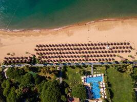 aerial view of a beach with beach chairs and palm trees, embodying the concept of a luxury summer island vacation with relaxation and idyllic getaway photo