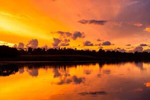 Amazing sunrise in rural scene Symmetry of the sky in a lake at sunset Clouds reflecting on the water Quiet relaxing scene with a beautiful colorful cumulonimbus photo