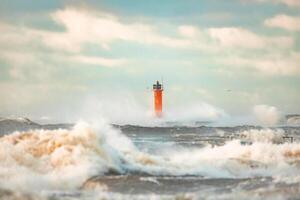 Lighthouse on the sea during Stormy weather in Riga, Latvia Huge waves crashing down the coast photo