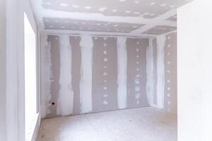 Interior of a house under renovation with drywall installation and joint compound application photo