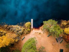 Aerial Drone view of colorful top of the forest and a lake at Autumn photo