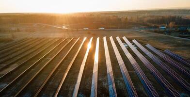 Aerial view of industrial sized solar panel farm during sunset, illustrating the blend of technology and nature photo